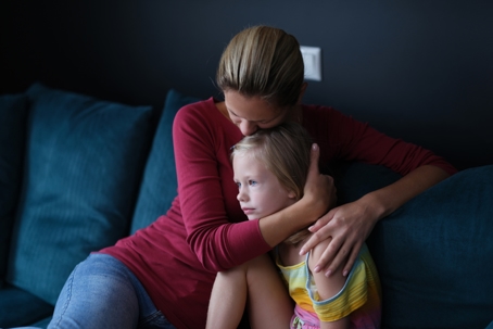 Search by image or video Woman and sad little daughter are sitting on couch