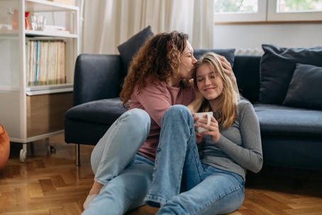 mother kissing daughter's head