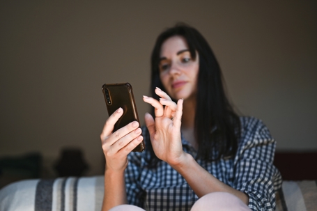 Close up of a woman typing on mobile phone.