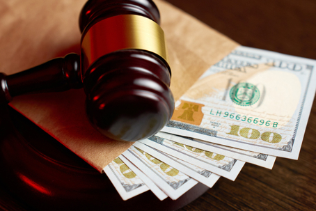 a gavel on top of an envelope of cash