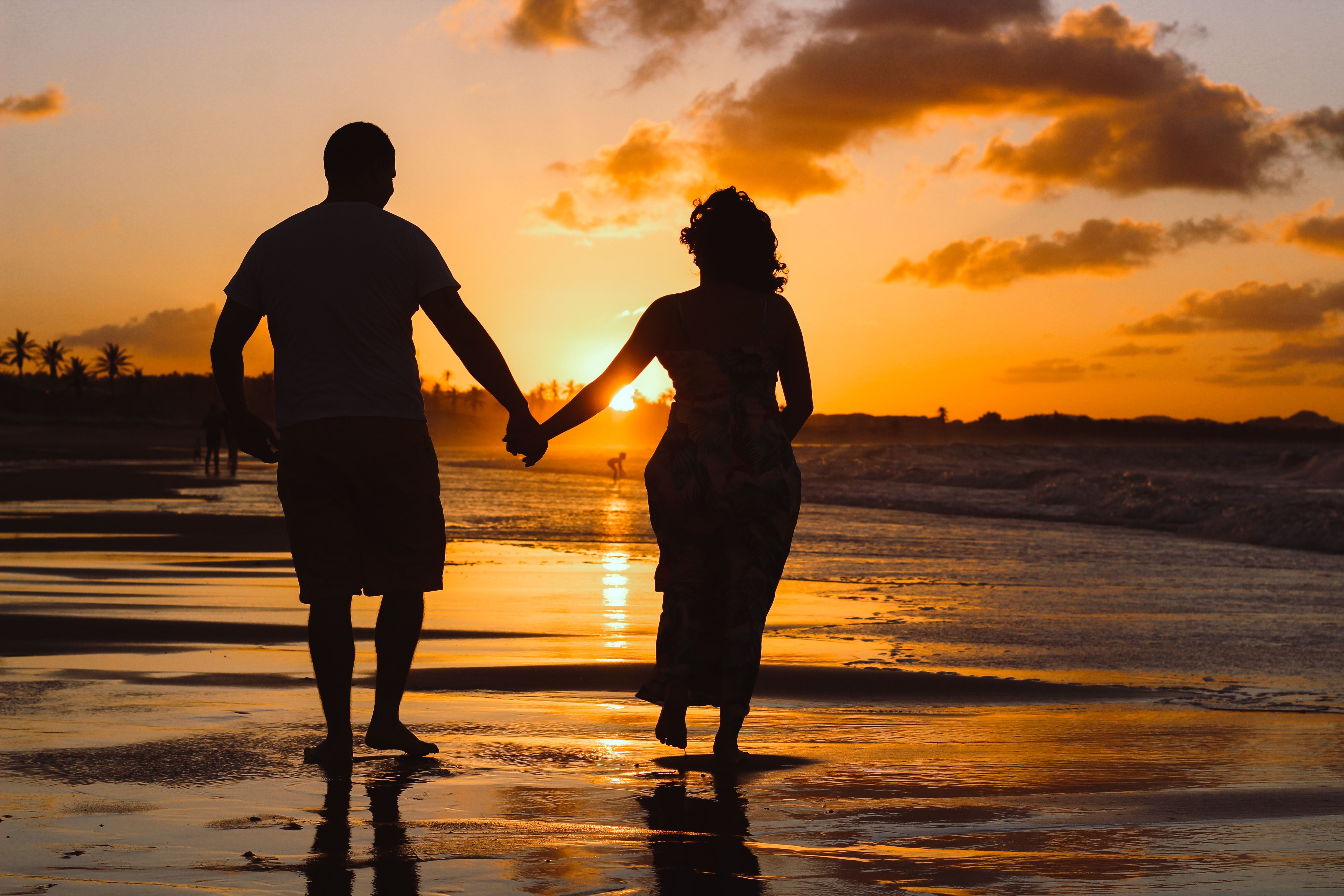 couple holding hands at sunset