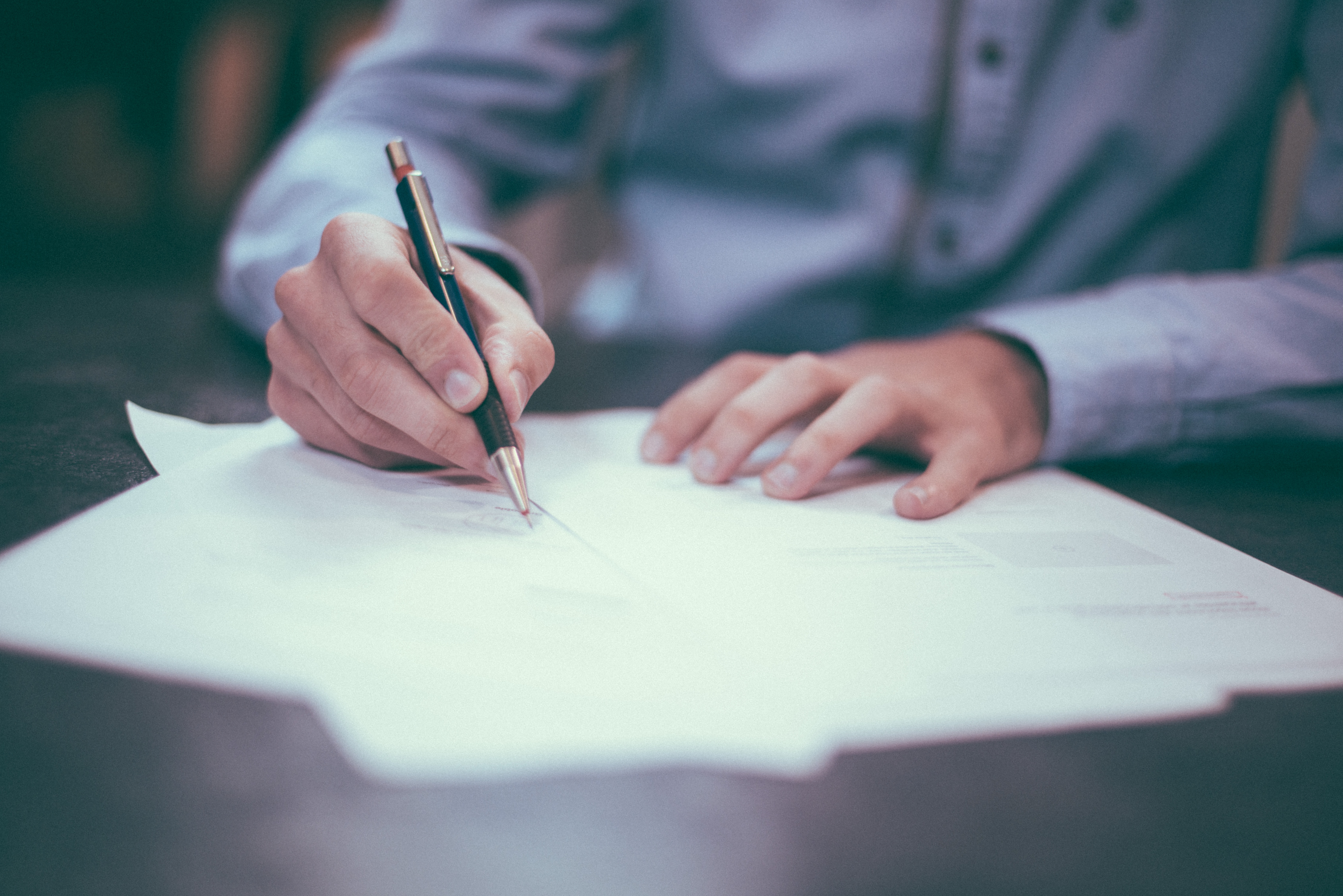 image of man writing at a desk